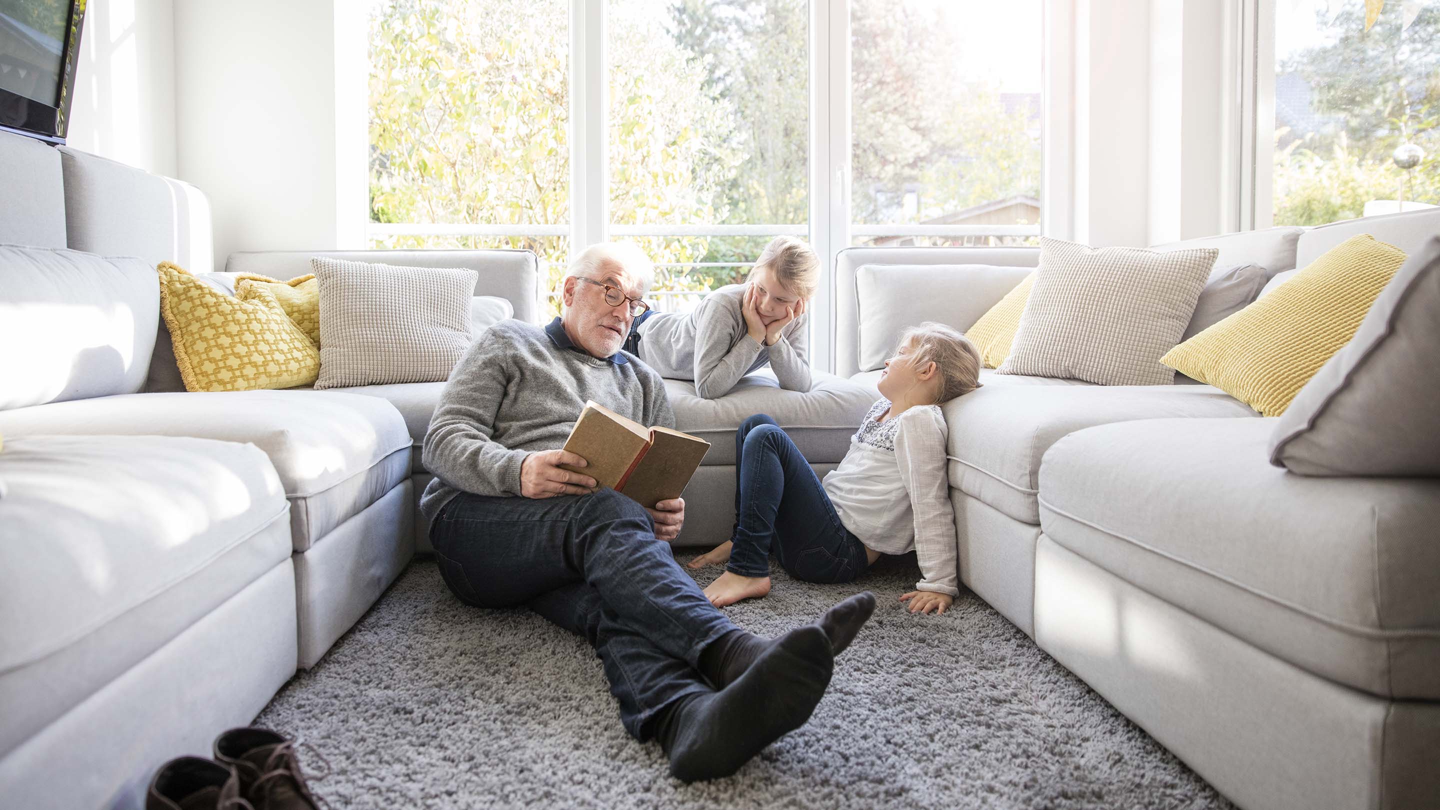 Grandad reading to two granddaughters